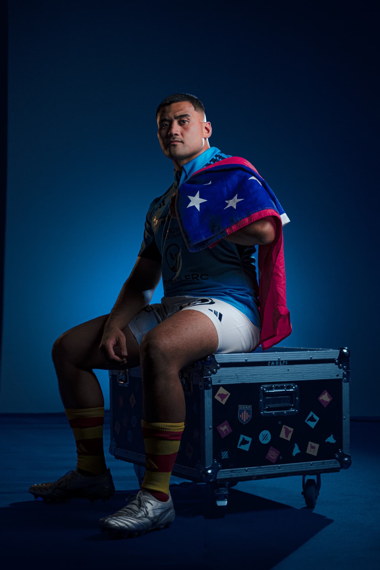 Sama Malolo, founder of Talon Coaching, wearing rugby kit and the Samoa flag